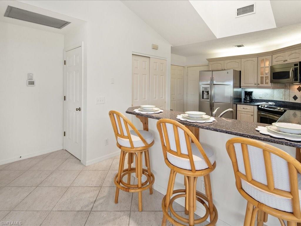 770 Eagle Creek Drive, Unit 301 Naples, FL 34113 - Photo 19 of 46 a kitchen with stainless steel appliances granite countertop a sink and cabinets