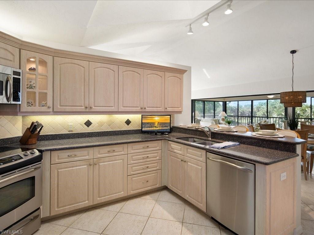 770 Eagle Creek Drive, Unit 301 Naples, FL 34113 - Photo 20 of 46 a kitchen with stainless steel appliances granite countertop a sink and cabinets