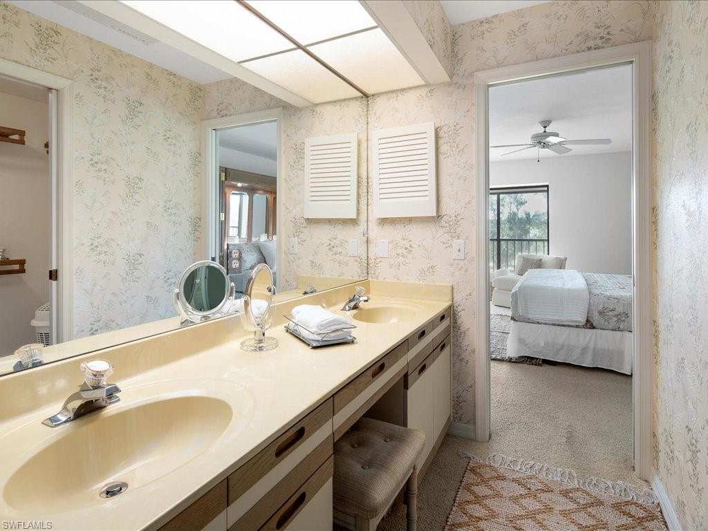 770 Eagle Creek Drive, Unit 301 Naples, FL 34113 - Photo 25 of 46 a en suite bathroom with a double vanity sink and a mirror
