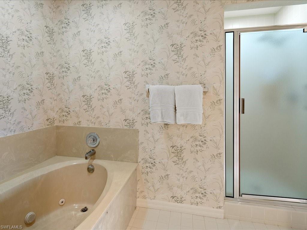 770 Eagle Creek Drive, Unit 301 Naples, FL 34113 - Photo 26 of 46 a bathroom with a tub and shower
