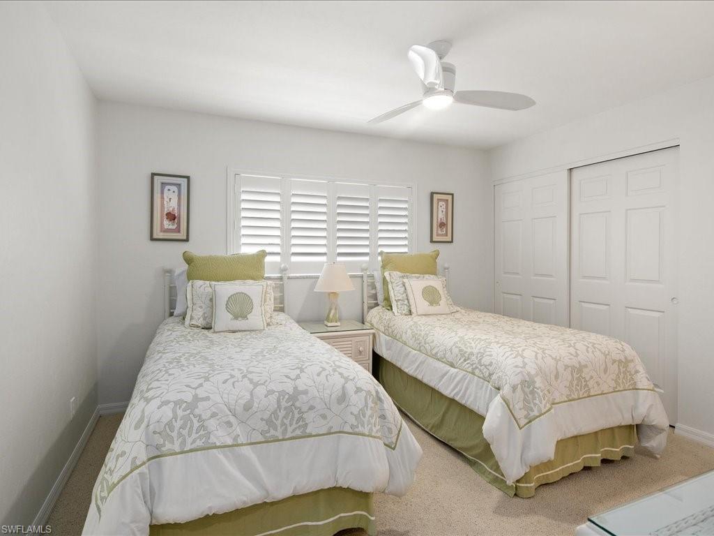 770 Eagle Creek Drive, Unit 301 Naples, FL 34113 - Photo 28 of 46 a bedroom with a bed and a lamp
