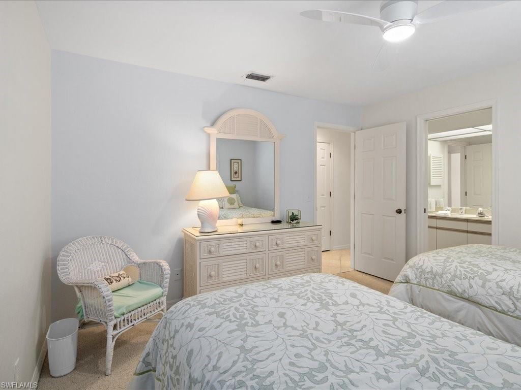 770 Eagle Creek Drive, Unit 301 Naples, FL 34113 - Photo 29 of 46 a bedroom with a bed and a chandelier