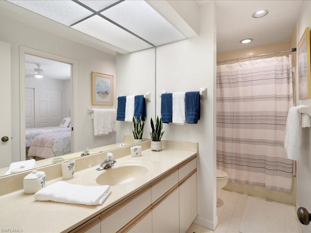 770 Eagle Creek Drive, Unit 301 Naples, FL 34113 - Photo 30 of 46 a bathroom with a double vanity sink and mirror