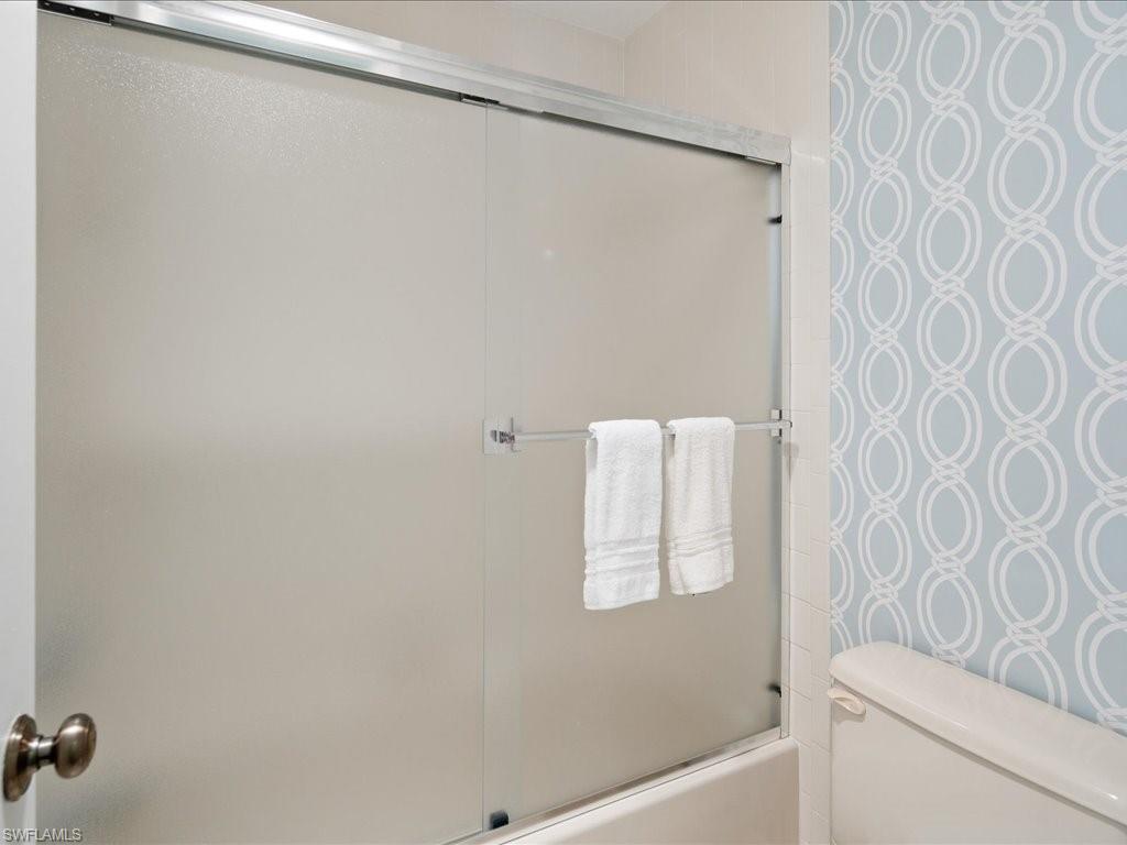 770 Eagle Creek Drive, Unit 301 Naples, FL 34113 - Photo 34 of 46 a bathroom with a shower curtain and a toilet