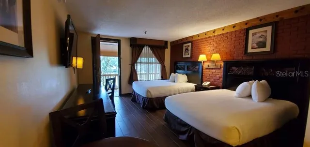 a living room with couches a flat tv screen and a fireplace with wooden floor