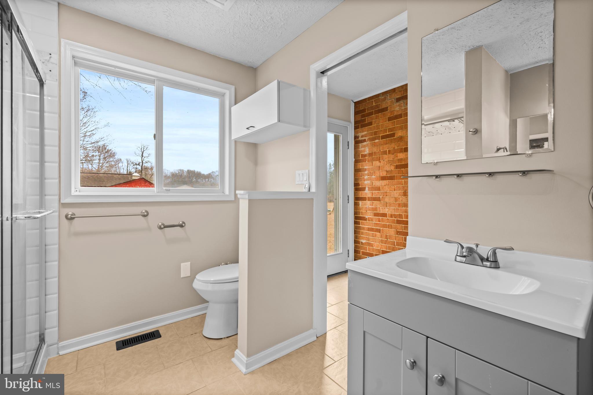 10514 Willetts Crossing Road White Plains, MD 20695 - Photo 18 of 41 a bathroom with a sink a toilet and a window