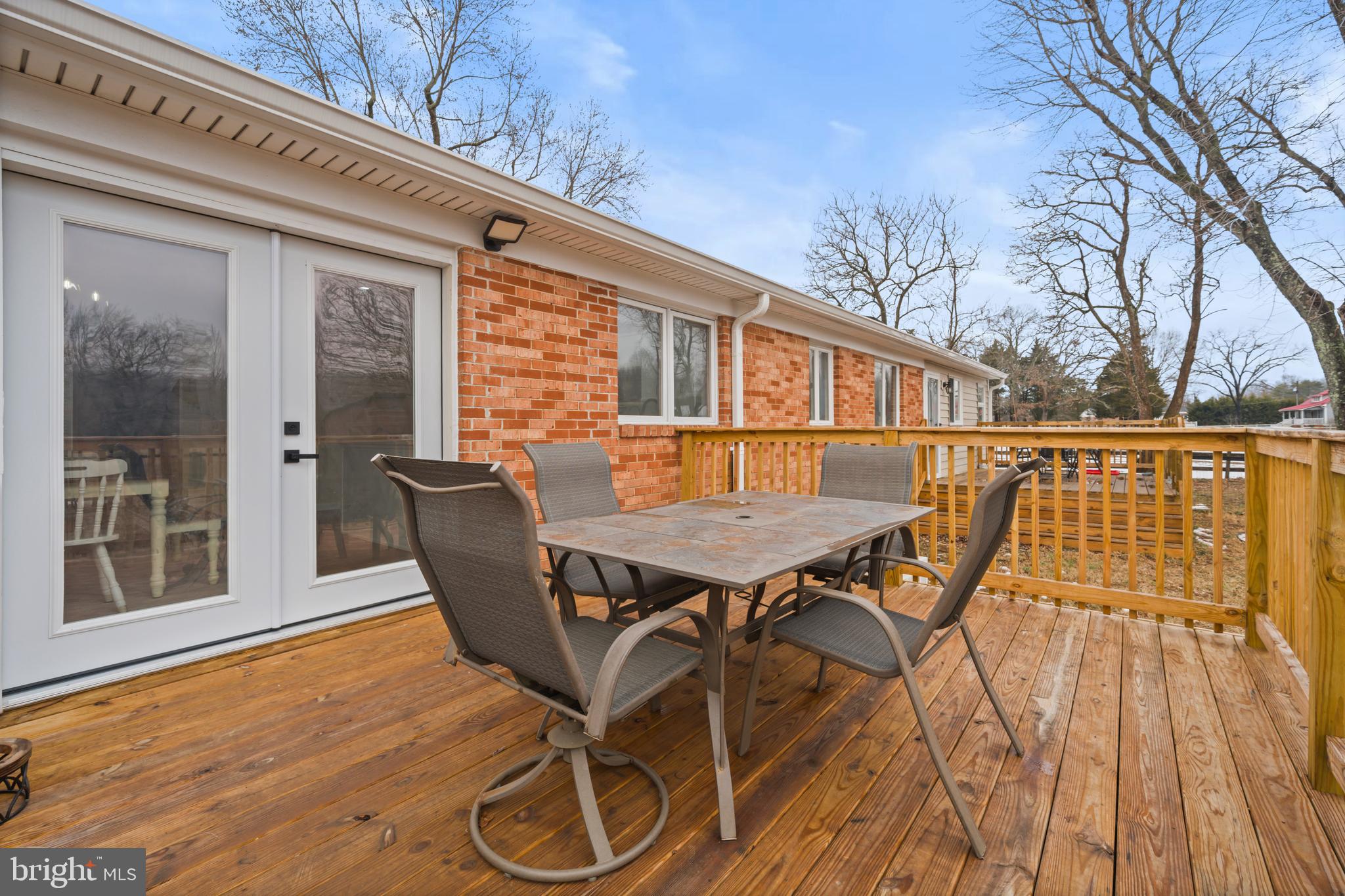 10514 Willetts Crossing Road White Plains, MD 20695 - Photo 35 of 41 a view of a patio with table and chairs with wooden floor and fence