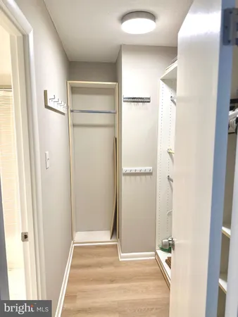 a view of a livingroom with wooden floor and a bathroom