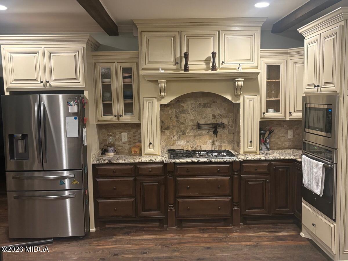 917 Broken Arrow Trail Perry, GA 31069 - Photo 20 of 34 a kitchen with stainless steel appliances granite countertop a refrigerator and a stove top oven