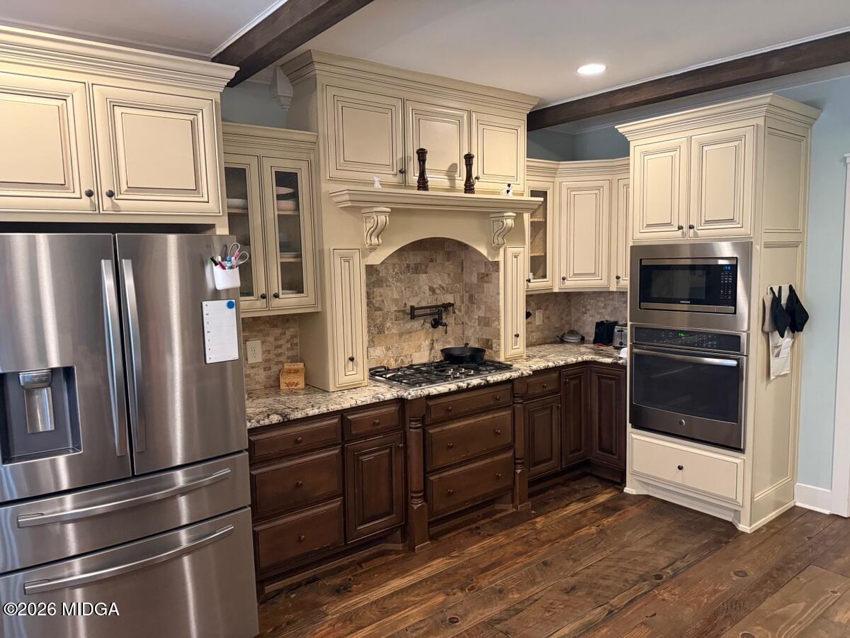 917 Broken Arrow Trail Perry, GA 31069 - Photo 23 of 34 a kitchen with stainless steel appliances granite countertop a refrigerator and a stove top oven