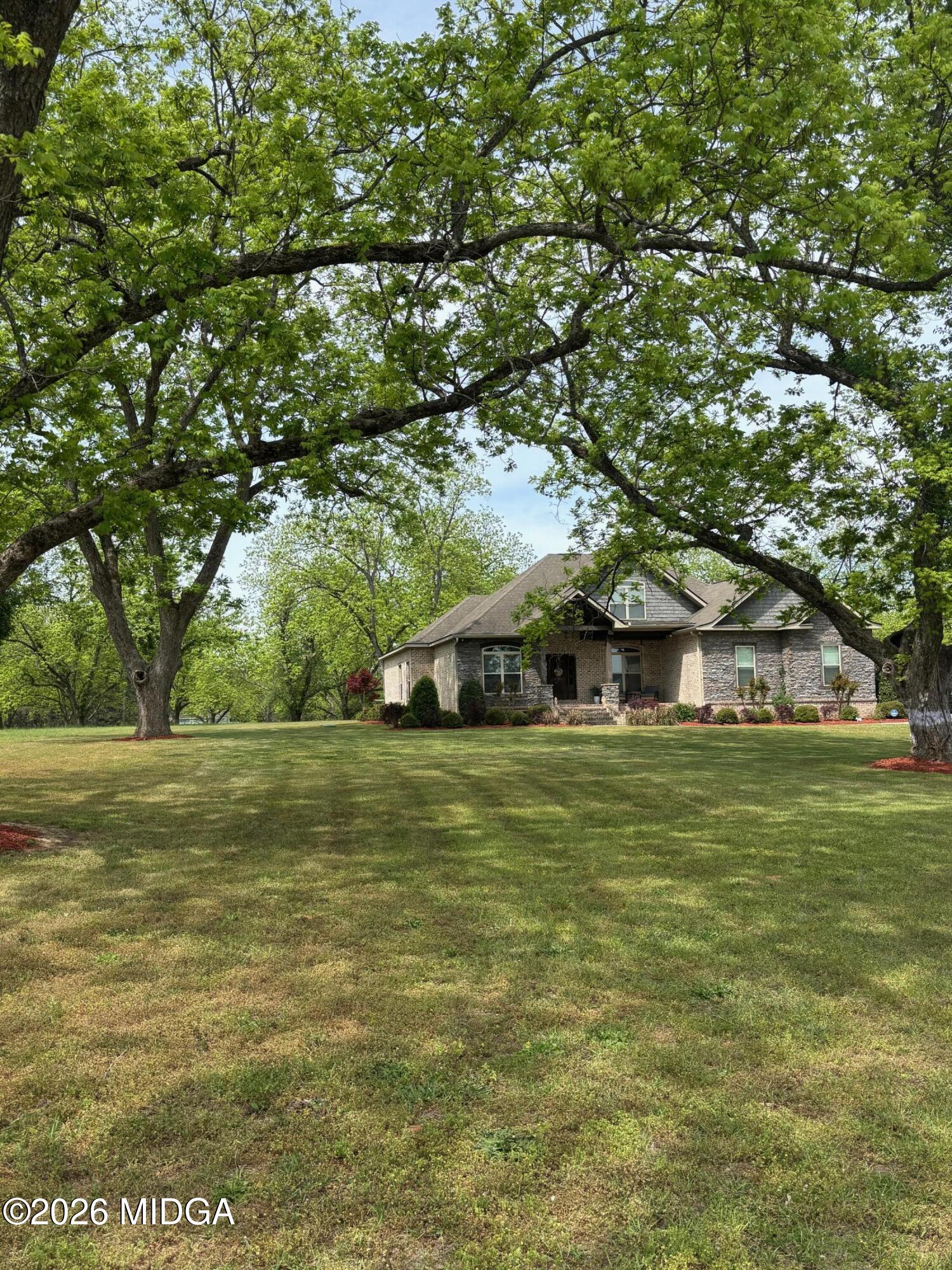 917 Broken Arrow Trail Perry, GA 31069 - Photo 3 of 34 a yellow house in middle of the forest