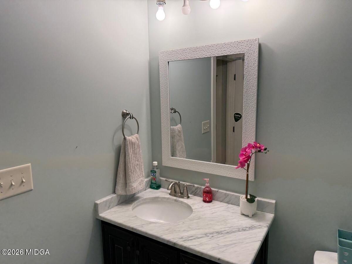 917 Broken Arrow Trail Perry, GA 31069 - Photo 32 of 34 a bathroom with a granite countertop sink and a mirror