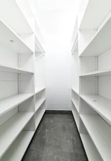 a kitchen with a refrigerator and white cabinets