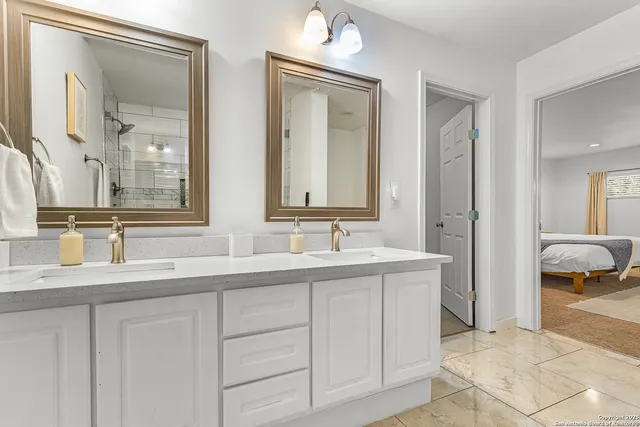 a en suite bathroom with double sink and a mirror