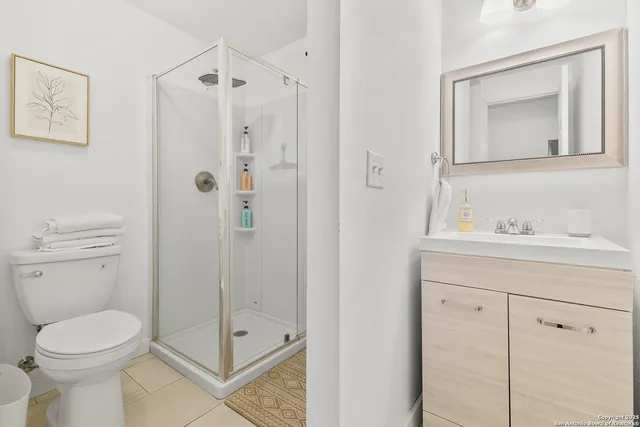 a bathroom with a toilet a sink a vanity and mirror