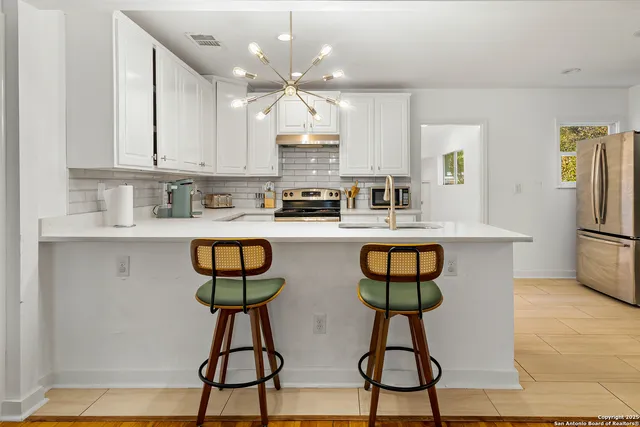 a kitchen with stainless steel appliances a counter space a sink and cabinets
