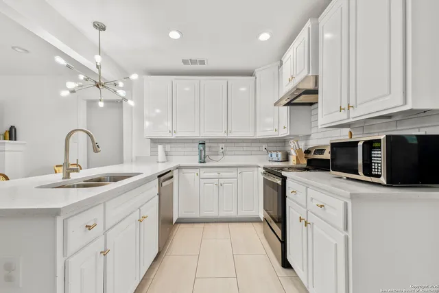 a kitchen with cabinets appliances a sink and a counter top