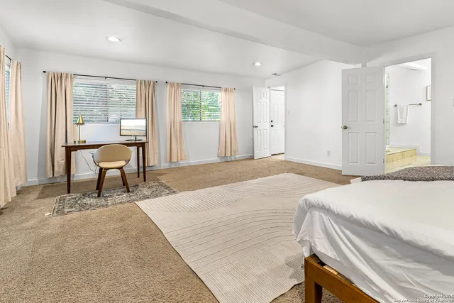 a bedroom with a bed and large windows