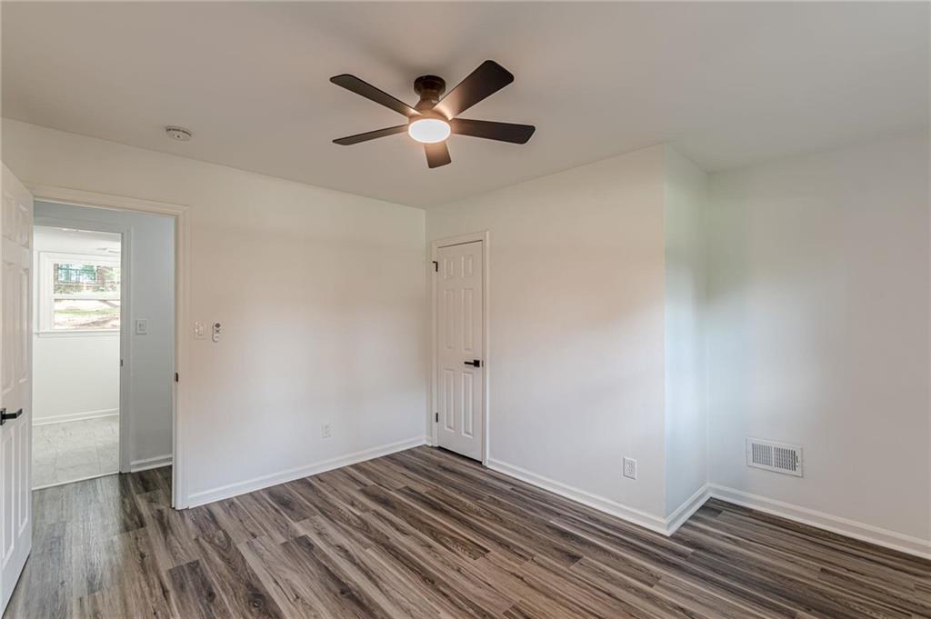2352 Glendale Drive Decatur, GA 30032 - Photo 32 of 39 an empty room with wooden floor a ceiling fan and windows
