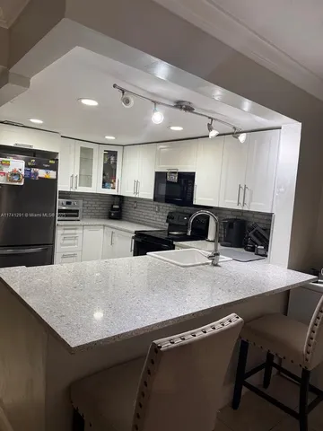 a kitchen with a kitchen island a stove and a refrigerator