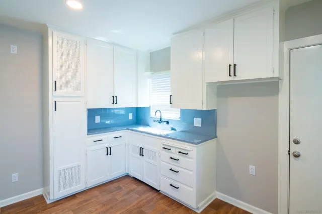 a kitchen with granite countertop white cabinets and white appliances