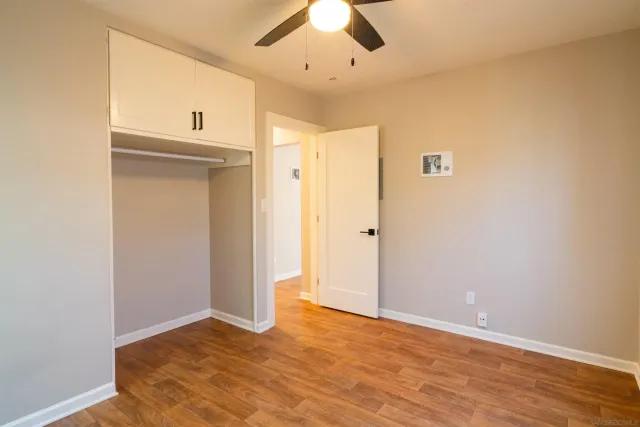 an empty room with closet and windows