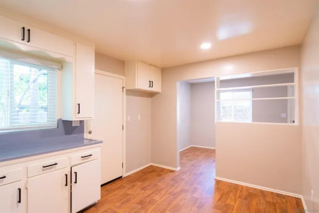 a kitchen with wooden floor and window