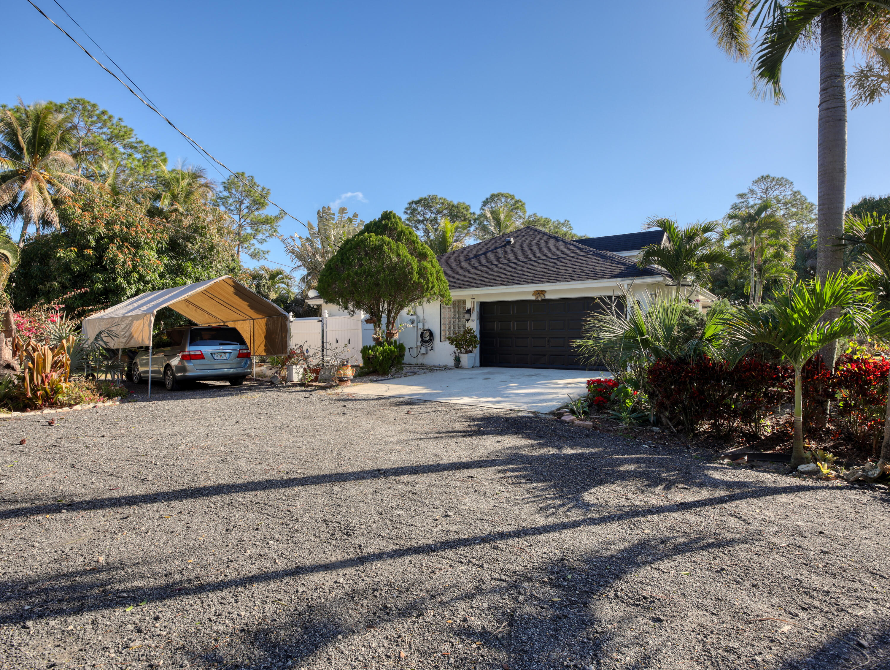 15049 85th Road North The Acreage, FL 33470 - Photo 13 of 60 a front view of a house with a garden and a yard