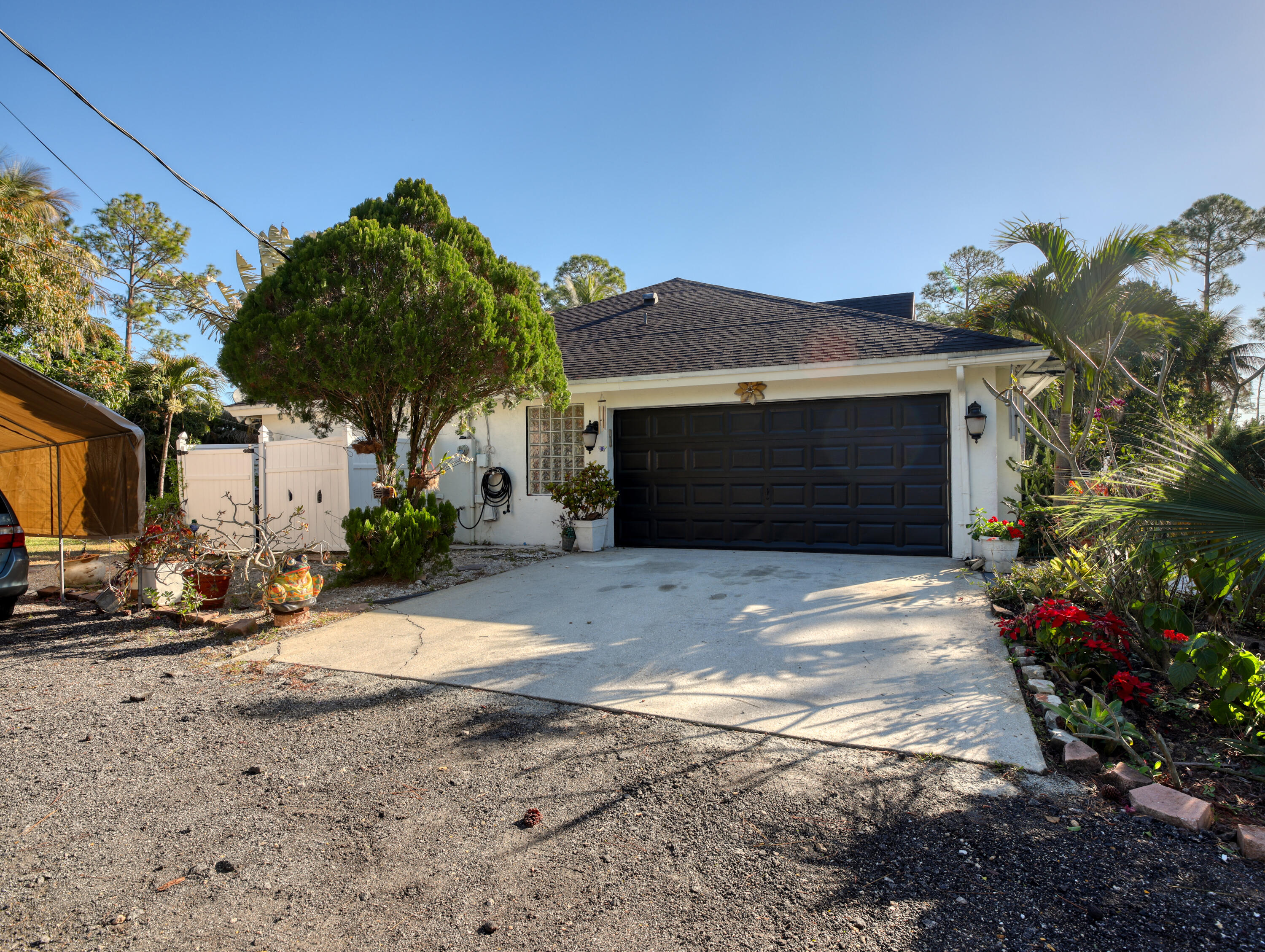15049 85th Road North The Acreage, FL 33470 - Photo 14 of 60 a front view of a house with a yard and a garage