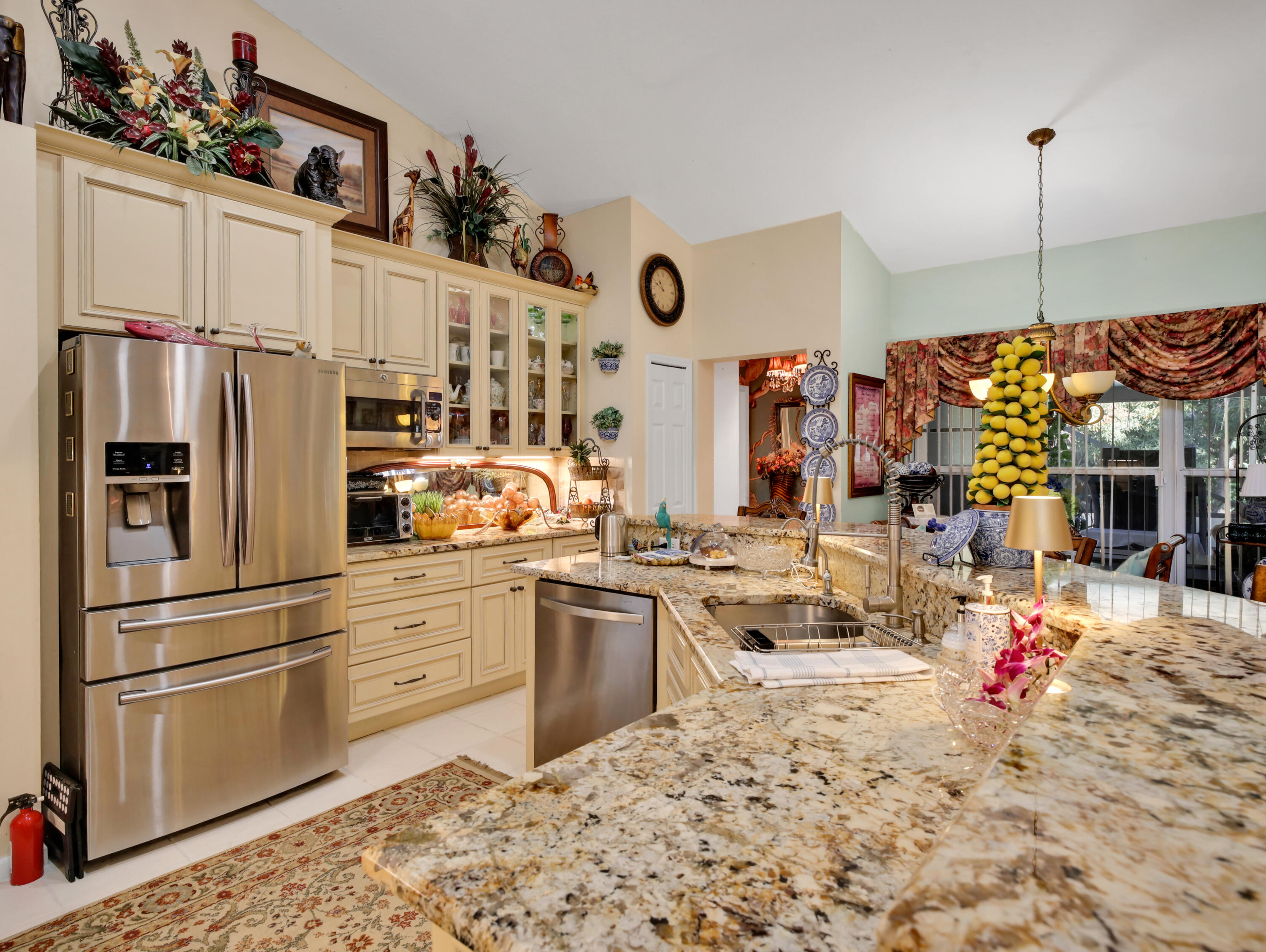 15049 85th Road North The Acreage, FL 33470 - Photo 31 of 60 a kitchen with stainless steel appliances kitchen island granite countertop a refrigerator and microwave