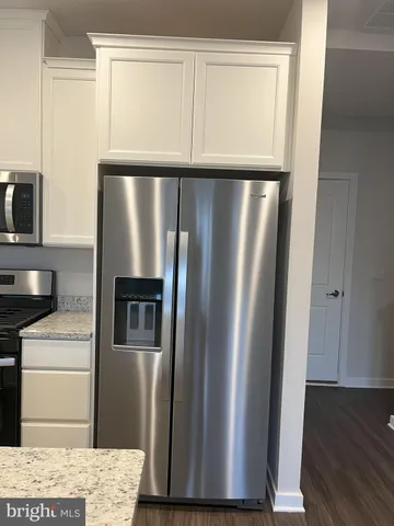 a metallic refrigerator freezer sitting in a kitchen
