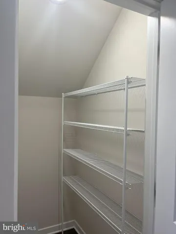 a view of walk in closet with empty racks