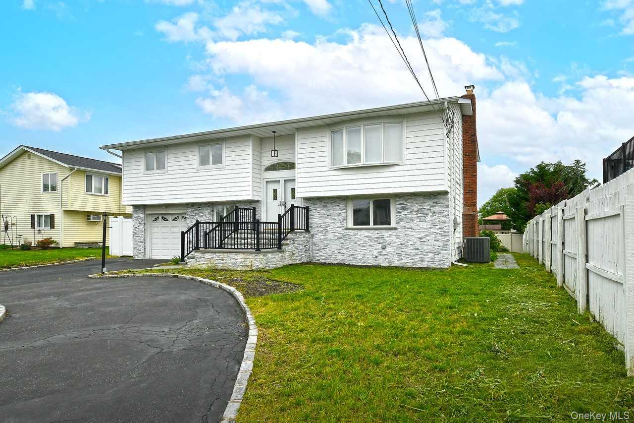 107 Beverly Road Massapequa, NY 11758 - Photo 2 of 41 a front view of a house with a yard and garage