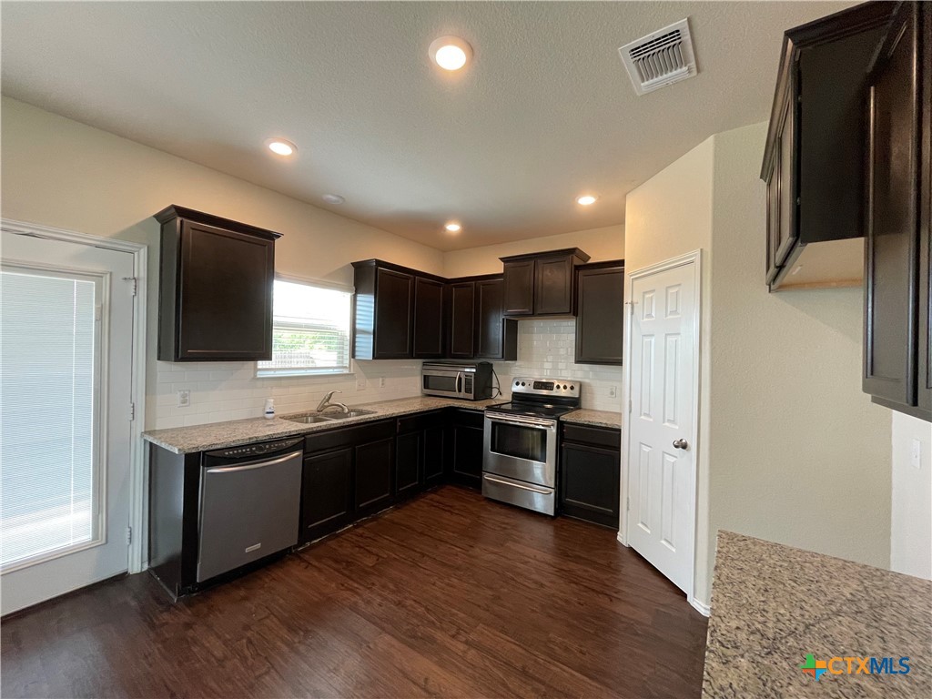 6416 Treiber Drive Temple, TX 76502 - Photo 6 of 19 a kitchen with stainless steel appliances granite countertop a sink stove and refrigerator