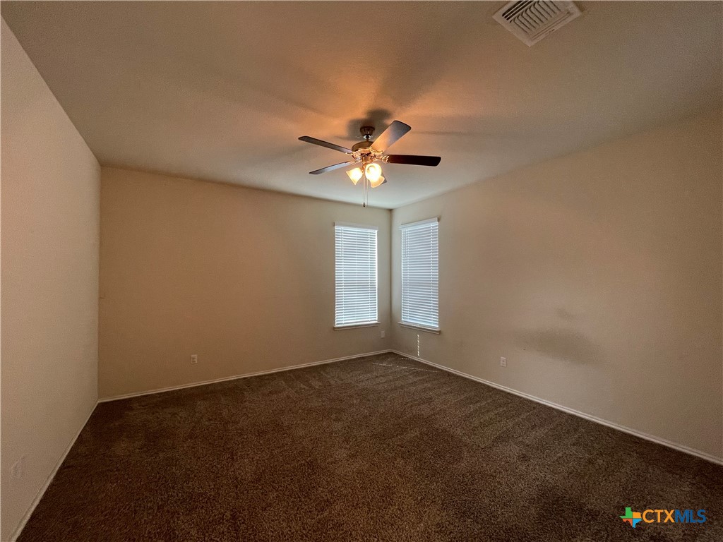 6416 Treiber Drive Temple, TX 76502 - Photo 8 of 19 an empty room with a chandelier fan and windows