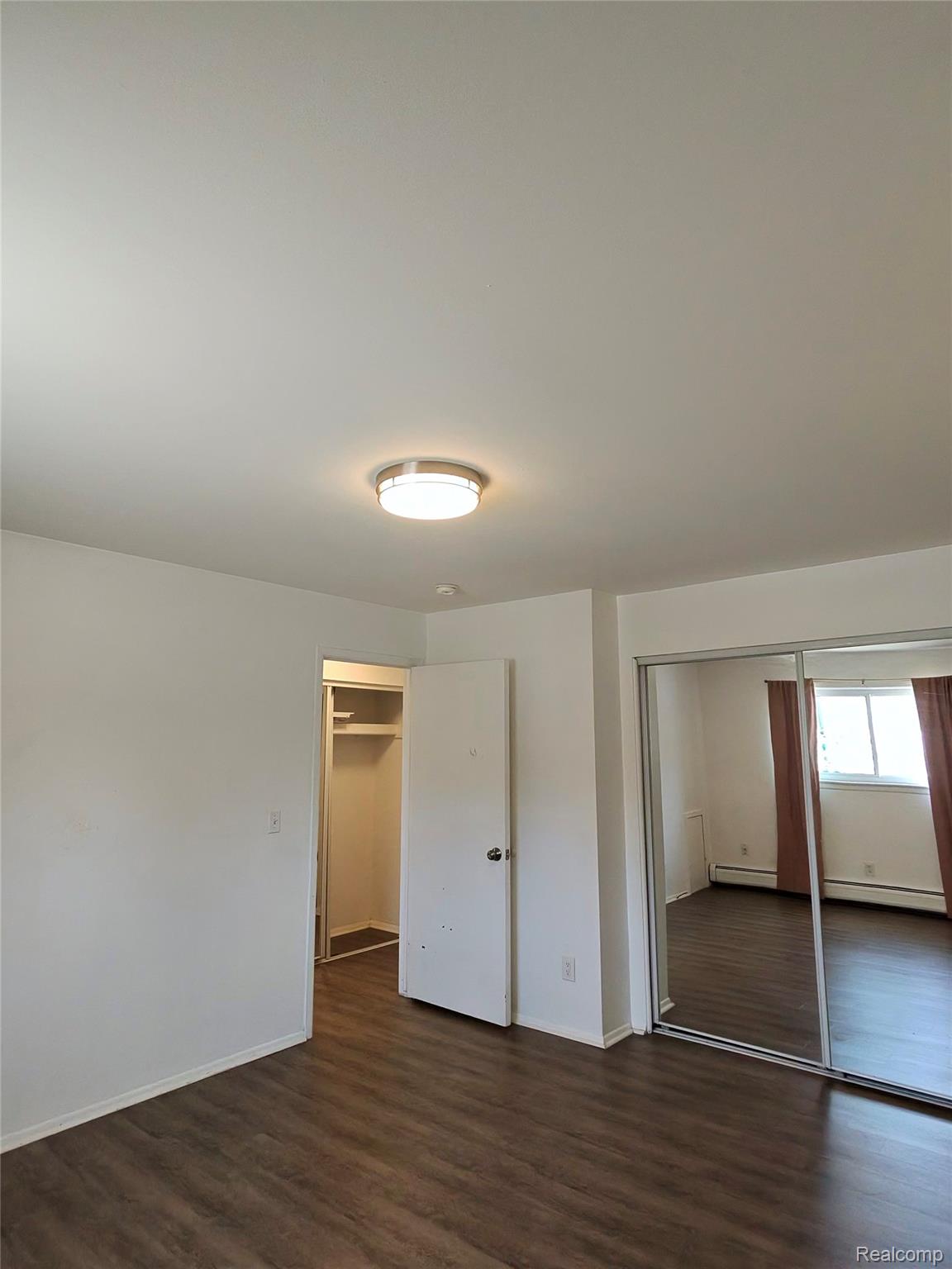 25301 Five Mile Road, Unit 130 Redford, MI 48239 - Photo 11 of 15 Spacious room featuring wood-finish flooring, white walls, and a contemporary flush-mount ceiling light