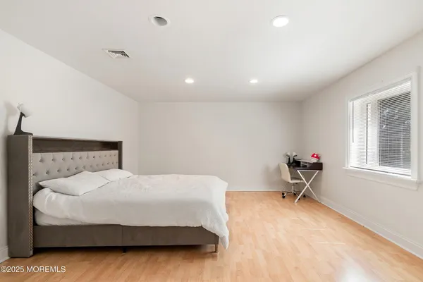 a spacious bedroom with a bed and a large window