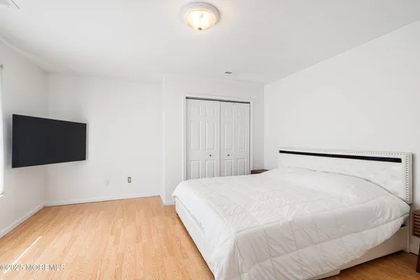 a view of a bedroom with a bed and a flat screen tv