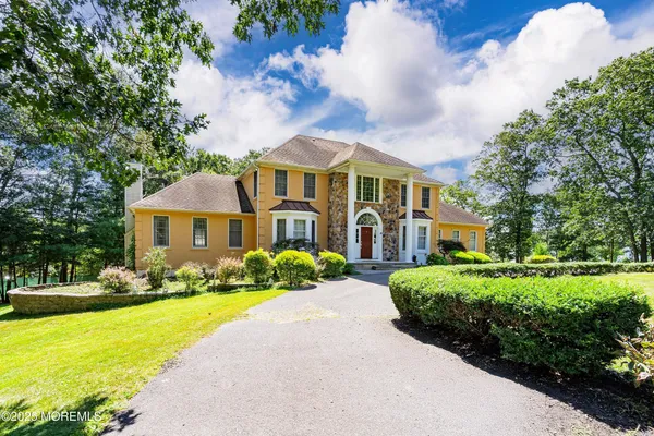a front view of a house with yard and green space