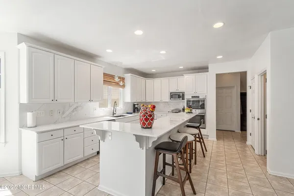 a kitchen with stainless steel appliances kitchen island granite countertop a sink and cabinets