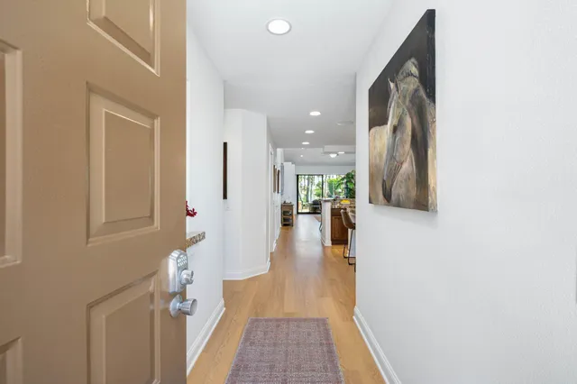 a view of a hallway with wooden floor and a living room