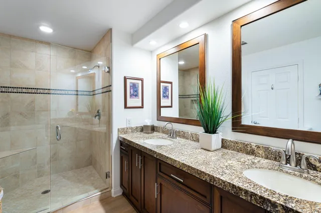 a bathroom with a granite countertop sink mirror and shower
