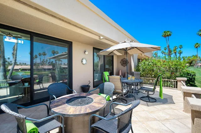 a view of a patio with dining table and chairs under an umbrella