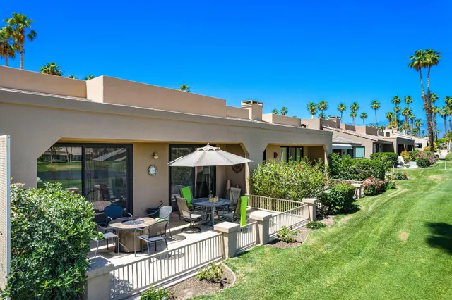 a view of house with backyard and outdoor seating