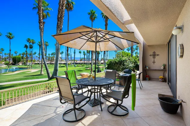a view of a patio with a table chairs and a fire pit