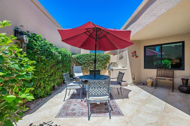 a view of a patio with chairs and potted plants