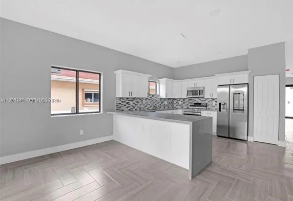 a kitchen with stainless steel appliances a refrigerator sink and cabinets