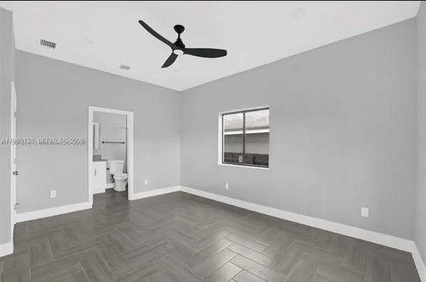 a view of empty room with wooden floor and windows