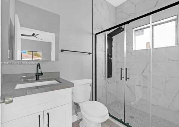 a bathroom with a sink toilet vanity and shower