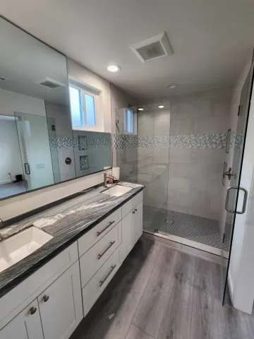 a bathroom with a granite countertop sink a toilet a shower and a mirror